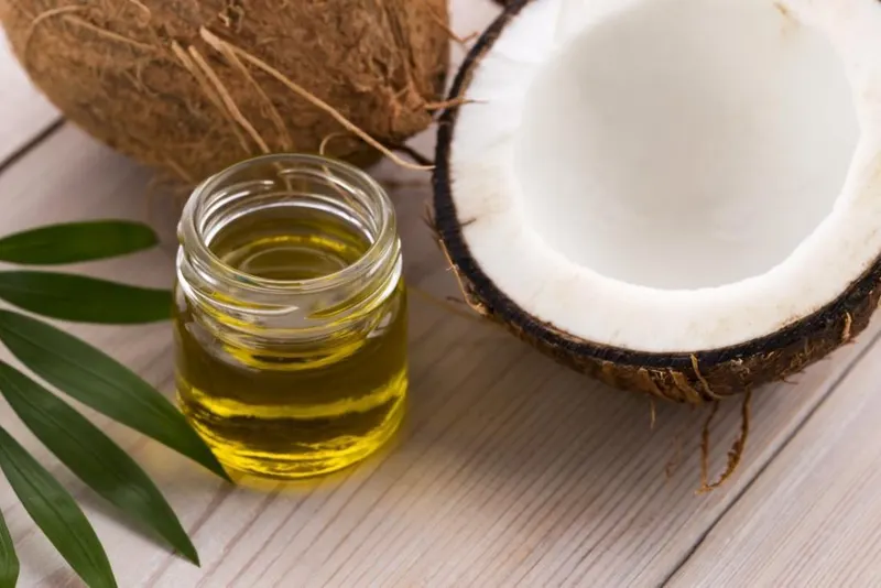 A coconut and oil in a glass jar.