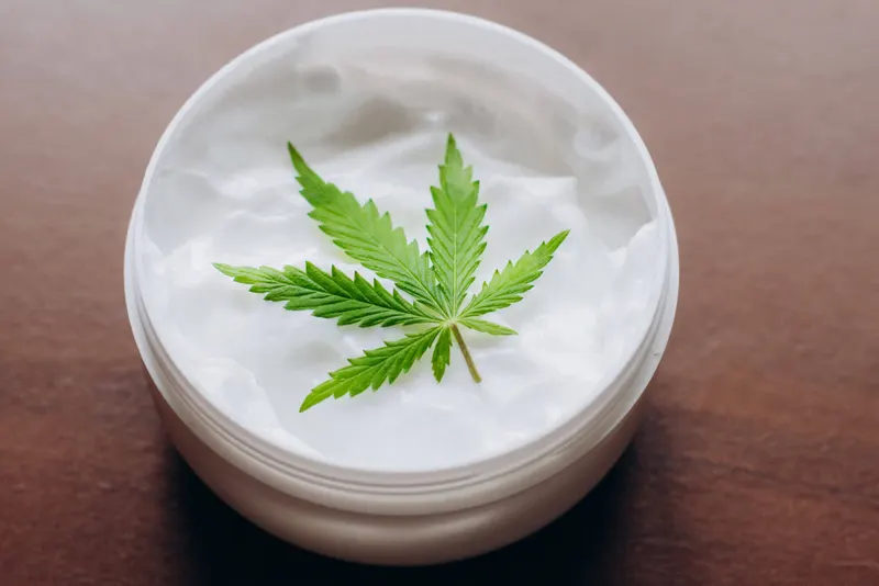 A cannabis leaf on a jar of cream.