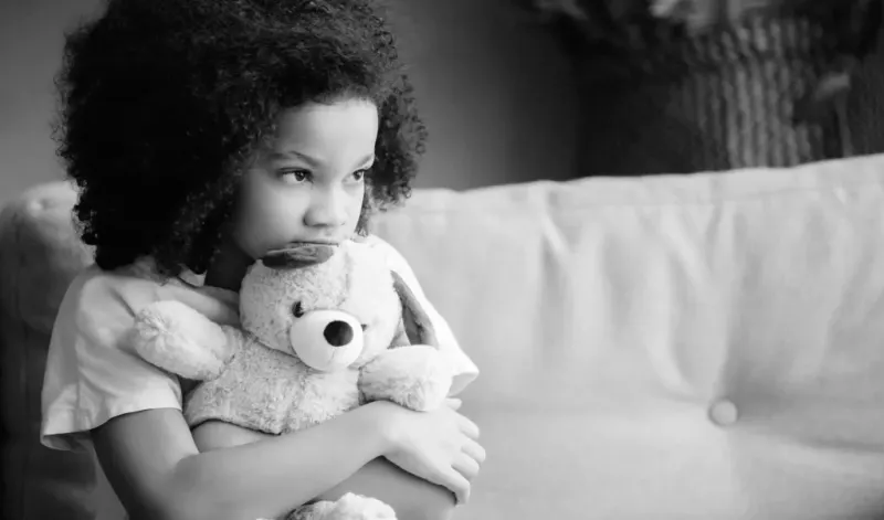 A child hugging a teddy bear.