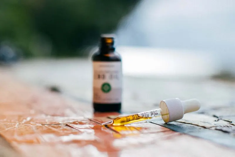 A close-up of a dropper and oil bottle.
